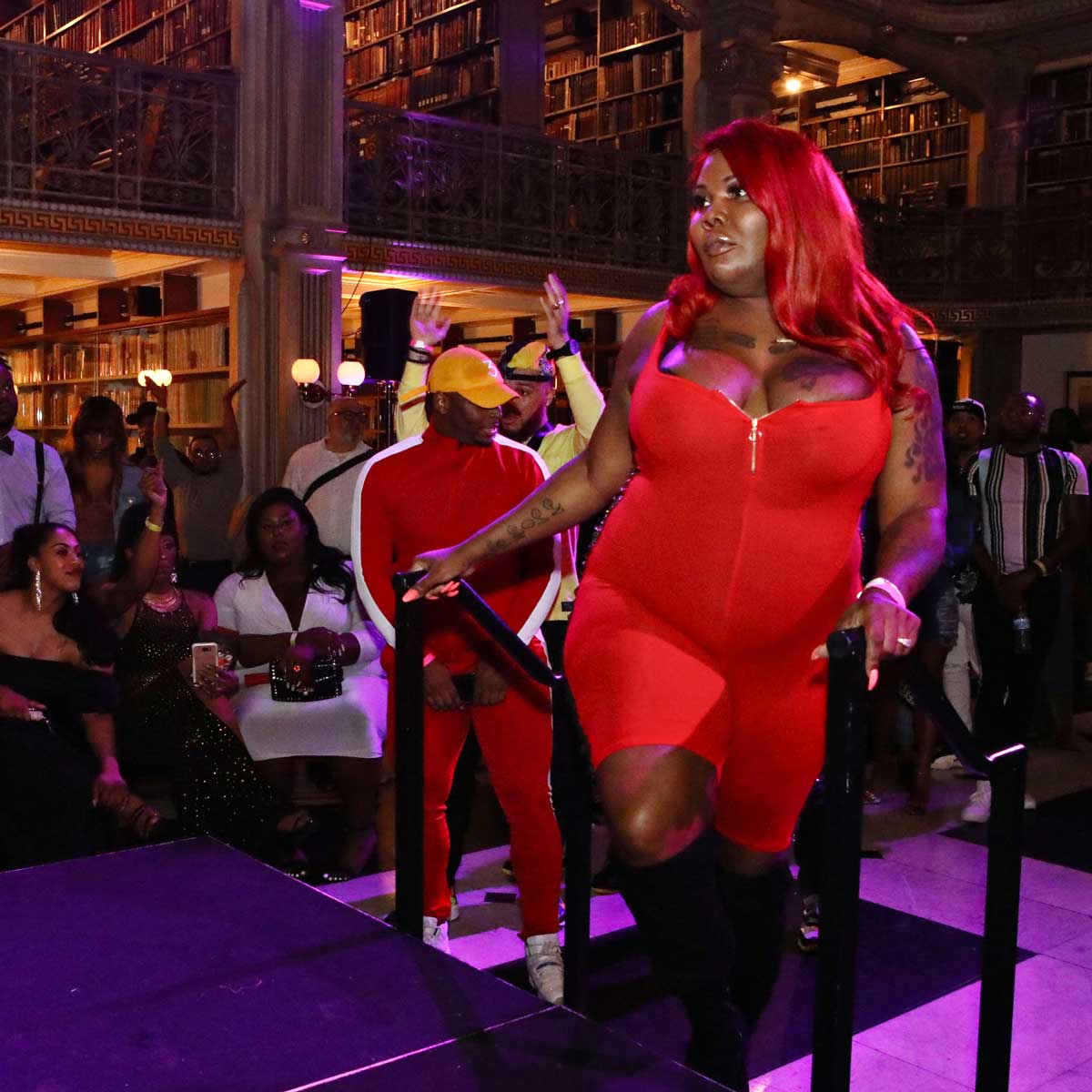 Performer in red bodysuit prepares to take the stage